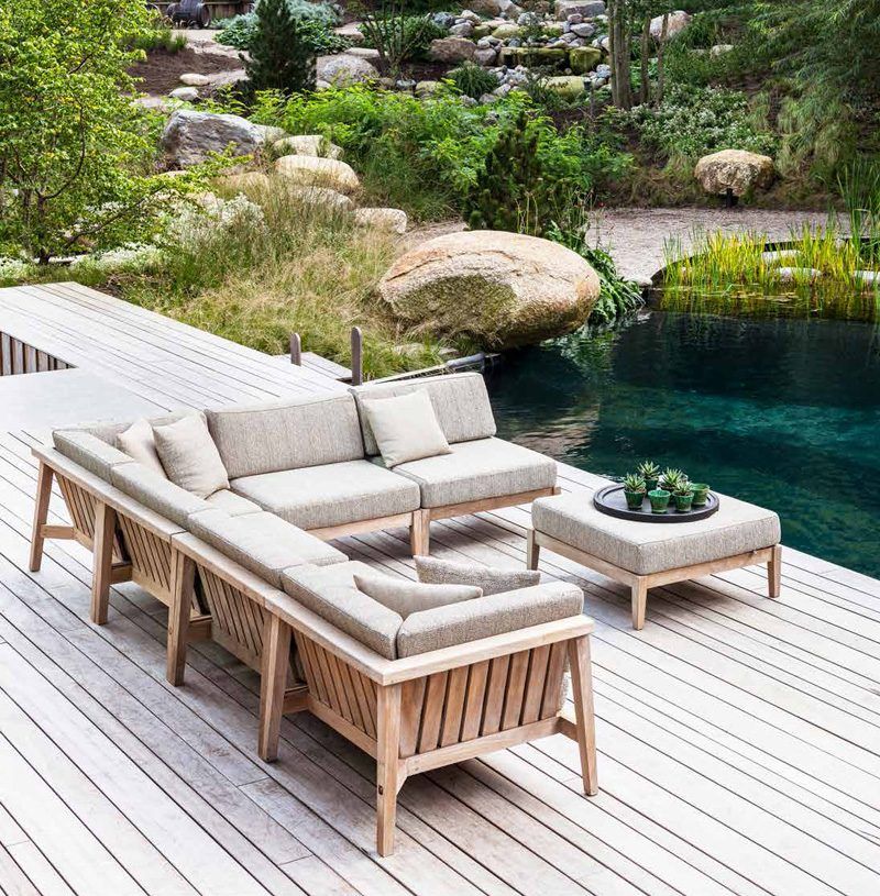 Gommaire Outdoor-Lounge aus Holz, neben natürlichem Teich.